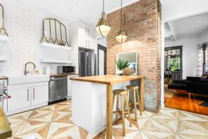 une cuisine avec des placards blancs et un mur en briques dans l'établissement Modern Midtown Getaway - Luxury Chic Unit ✧, à Atlanta