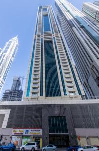 杜拜的住宿－Amazing Rooms for Men Guests for rent in Dubai Marina，一座高大的建筑,前面有汽车停放