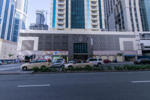 a parking lot with cars parked in front of a building at Amazing Rooms for Men Guests for rent in Dubai Marina in Dubai