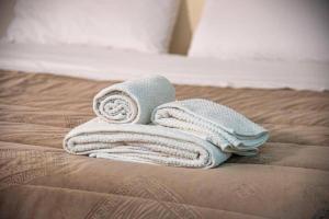 a pile of towels sitting on top of a bed at Campania Apartment Vesuvio Comfort -150m dalla stazione - 5km da Pompei in Poggiomarino