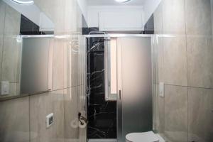 a bathroom with a shower with a toilet and a mirror at Campania Apartment Vesuvio Comfort -150m dalla stazione - 5km da Pompei in Poggiomarino