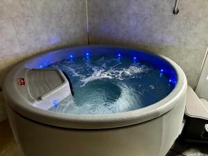 een jacuzzi met blauwe verlichting in de badkamer bij OXXOTEL in Valognes