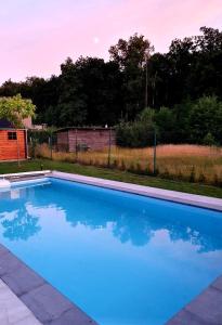 una gran piscina azul en un patio en Chalet Mésange, en Érezée