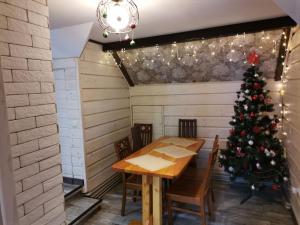 a christmas tree in a room with a table and chairs at Zaviy in Yaremche