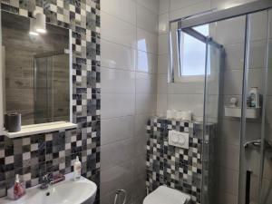 a bathroom with a sink and a toilet and a mirror at RoomsApartments PopCOURT in Pančevo