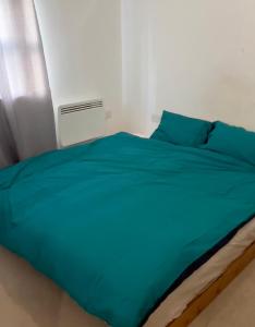 a bed with a blue comforter in a bedroom at Central Town Apartment in Kent