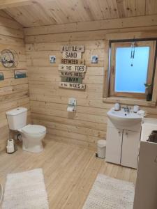 baño de madera con aseo y lavamanos en Luxury log cabin with wood fired hot tub en Moville