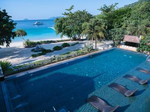 uma piscina de beiral infinito com cadeiras e praia em Victoria Cliff Resort Nyaung Oo Phee Island em Nga Khin Nyo Gyee Island