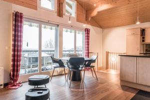 - une cuisine et une salle à manger avec une table et des chaises dans l'établissement Chalet Eiger View - GRIWA RENT, à Grindelwald