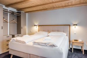 - une chambre avec un grand lit blanc et une table dans l'établissement Chalet Eiger View - GRIWA RENT, à Grindelwald