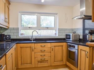 a kitchen with a sink and a microwave at Willow Cottage 