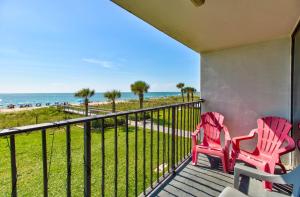 two chairs sitting on a balcony overlooking the beach at 0208 Tiki Tower by Atlantic Towers in Carolina Beach +17 photos