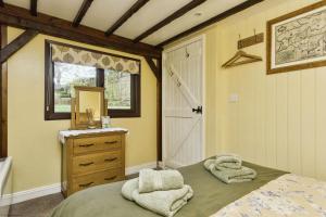 a bedroom with a bed and a sink and a mirror at Lavender Cottage in Arreton