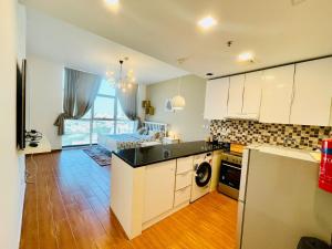 a kitchen with white cabinets and black counter tops at Studio apartment in Jumeriah village triangle in Dubai