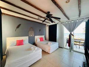 1 dormitorio con 2 camas y vistas al océano en Hotel Arenas Mahahual en Mahahual