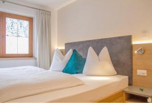 a bedroom with a bed with blue and white pillows at Apart Prieth Samnaun in Samnaun