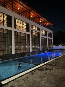 una persona en una piscina frente a un edificio en Krown Palace Resort, en Silvassa