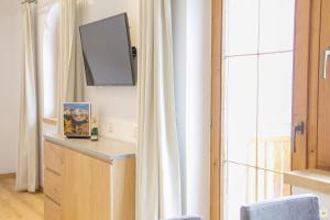 um quarto com uma televisão na parede ao lado de uma janela em Apart Prieth Samnaun em Samnaun