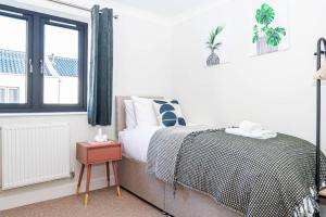 1 dormitorio con cama y ventana en Coastal Comfort Getaway, en Portsmouth