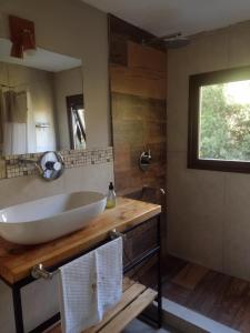 baño con lavabo blanco grande y espejo en Casa Mora en San Carlos de Bariloche