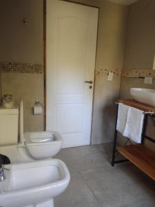 y baño con aseo blanco y lavamanos. en Casa Mora en San Carlos de Bariloche