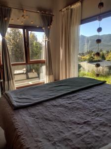 1 dormitorio con 1 cama grande y ventana grande en Casa Mora en San Carlos de Bariloche