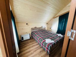 1 dormitorio con 1 cama en una cabaña de madera en Cottage Am Museum, en Mestia