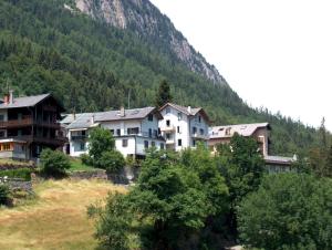 a group of houses in front of a mountain at B&B Les Rochers 42 lits in Les Marécottes