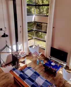 sala de estar con cama y ventana grande en Casa Mora en San Carlos de Bariloche