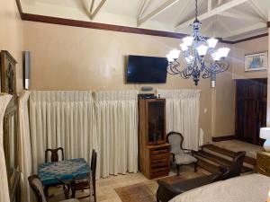 a bedroom with a bed and a tv and a chandelier at Sweet Dreams Guest House in Melkbosstrand