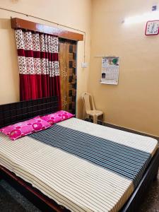 PerambalūrにあるSirvachur madhurakalli amman guest houseのベッドルーム1室(赤いカーテン付きの大型ベッド1台付)