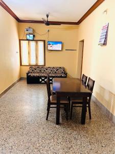Cette chambre comprend une table, des chaises et un lit. dans l'établissement Sirvachur madhurakalli amman guest house, à Perambalūr