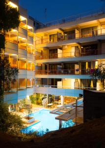 um edifício de apartamentos com piscina à noite em Apollonia Hotel Apartments em Varkiza