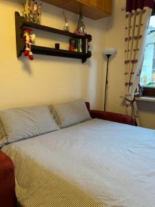 um quarto com uma cama com uma colcha branca e uma janela em Gina's Home - Appartamento nel cuore di Bardonecchia em Bardonecchia