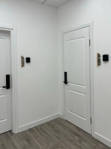 Duas portas num quarto com paredes brancas e pisos de madeira em Express Inn em Poti