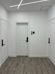 an empty room with white doors and wooden floors at Express Inn in Poti