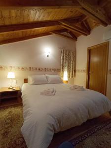 a bedroom with a large white bed in a room at Σύγχρονη αγροικία in Nafpaktos