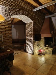 a brick room with a fireplace and a tv at Σύγχρονη αγροικία in Nafpaktos