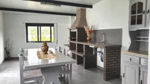 cocina con mesa y chimenea de ladrillo en Casa Barbeiro, en Pombal