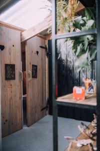 una porta aperta per una camera con pareti in legno di Luxe Lodge Tent ad Alphen
