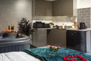 a kitchen with a table with flowers on it at Riverside studio with Jacuzzi! in Sheffield