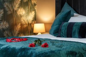 a bed with red roses on a blue blanket at Riverside studio with Jacuzzi! in Sheffield