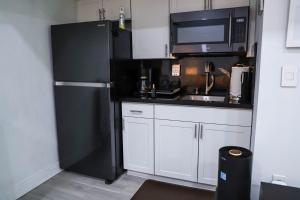 a kitchen with a black refrigerator and a microwave at VILLA GUILLA in Miami