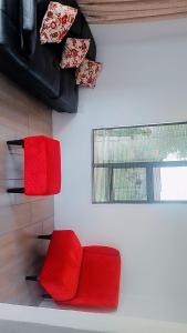 een woonkamer met rode stoelen en een raam bij Bakoena's full house in Newcastle