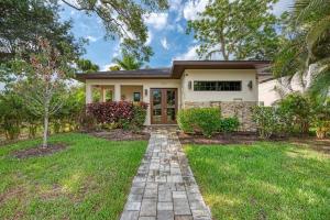 a home with a brick pathway leading to the front door at Courtyard Home with Pool, Spa & Sauna close to Beach & City Center in Sarasota