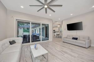 uma sala de estar com um sofá e uma televisão de ecrã plano em Courtyard Home with Pool, Spa & Sauna close to Beach & City Center em Sarasota