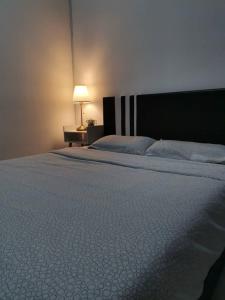 a bedroom with a bed and a lamp on a table at Muji Style brick themed Cameron Highland Homestay FREE Netflix in Tanah Rata