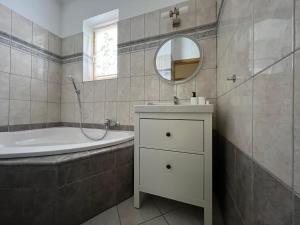 ein Badezimmer mit einem Waschbecken, einer Badewanne und einem Spiegel in der Unterkunft Klimó apartment in Pécs