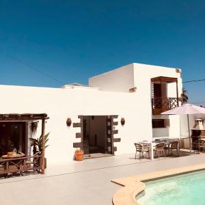 ein weißes Haus mit einem Pool und einer Terrasse in der Unterkunft Bodega Botanica - Shared Pool - Central Island Location - 10 mins drive to Famara and La Santa in Tiagua