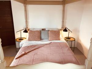 ein Schlafzimmer mit einem Bett mit zwei Lampen auf zwei Tischen in der Unterkunft Bodega Botanica - Shared Pool - Central Island Location - 10 mins drive to Famara and La Santa in Tiagua